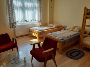 a room with two beds and a glass table at Willa Marylka in Piwniczna