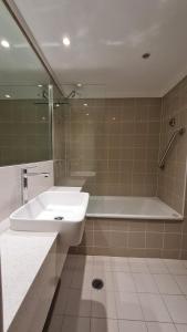 y baño con lavabo, ducha y bañera. en Chatswood Hotel Apartment en Sídney