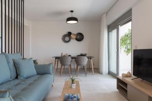 a living room with a blue couch and a table at Kallithea Residence in Rethymno