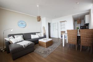 ein Wohnzimmer mit einem Sofa und einem Tisch in der Unterkunft Haus Uthlande Uthlande Whg 49 Inselauszeit in Wyk auf Föhr