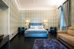 a hotel room with a bed and a couch at Via Veneto Suites in Rome