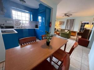 a kitchen and living room with a wooden table and chairs at 3BR sleeps up to 12, Remodeled and Very Cozy in Catano