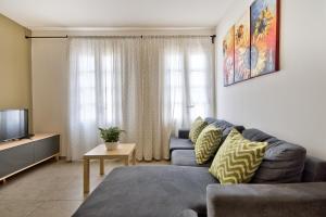 - un salon avec un canapé et une télévision dans l'établissement CityVista - Gzira Apartments and Penthouse by ShortletsMalta, à Il-Gżira