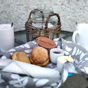 a basket of food on a table with cups of coffee at Forest View - Castlewellan, County Down in Belfast