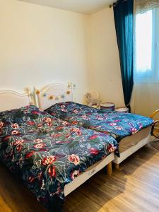 1 dormitorio con 1 cama con colcha de flores en Almanarre en Hyères