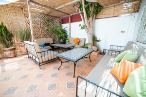 a patio with a table and chairs at Original Surf Morocco in Tamraght Ouzdar