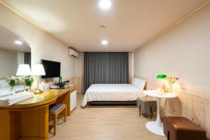 Postel nebo postele na pokoji v ubytování New Jeju Hotel