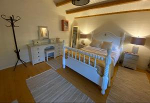 a bedroom with a white bed and a dresser at Beaufort House Accomodation in New Ross