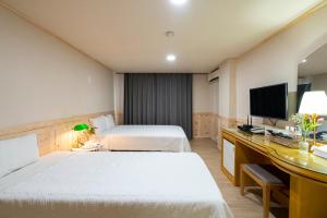 Postel nebo postele na pokoji v ubytování New Jeju Hotel