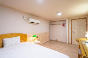 Postel nebo postele na pokoji v ubytování New Jeju Hotel