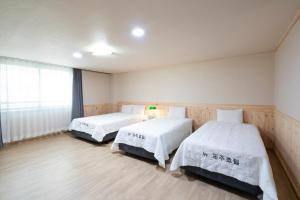 Postel nebo postele na pokoji v ubytování New Jeju Hotel