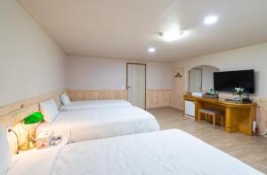 Postel nebo postele na pokoji v ubytování New Jeju Hotel