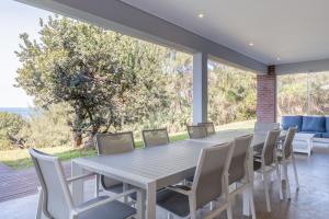a dining room with a table and chairs at NKWAZI COTTAGE, 77 Nkwazi Drive, Zinkwazi beach in Zinkwazi Beach