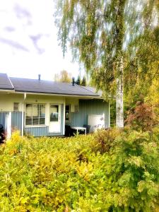uma casa com um monte de arbustos na frente dela em Cozy house with sauna 10 min walk to Santa Claus Village em Rovaniemi