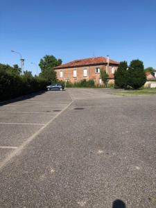 a parking lot with a car parked in front of a building at Le Studio Saint Martin - Piscine & Spa - Aéroport in Toulouse