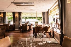 a restaurant with a dining room with tables and chairs at De Stobbe hotel & suites in Ruinen