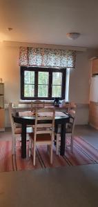 uma sala de jantar com uma mesa e cadeiras e uma janela em Ainola em Hämeenlinna