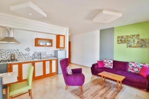 a living room with a purple couch and a kitchen at Çınarlar Apart Hotel KAŞ in Kaş