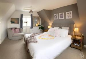 a bedroom with a large white bed and a chair at The Loft at Peake’s retreats in Needwood