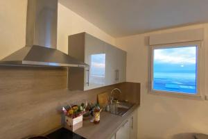 una cocina con fregadero y ventana en Front de mer à Wimereux - Wifi-, en Wimereux
