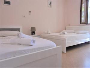 two beds in a white room with towels on them at Zace Studios in Ksamil