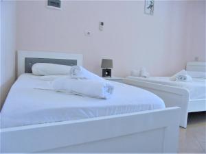 - 2 lits dans une chambre blanche avec des serviettes dans l'établissement Zace Studios, à Ksamil