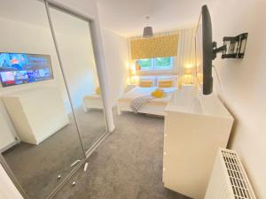 a small bedroom with a bed and a mirror at Paisley Central Apartment in Paisley