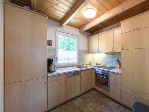 a kitchen with wooden cabinets and a window at Haus Himmelblau am Jabeler See in Jabel