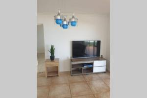 KingsboroughにあるLa Mer Stunning Beachfront Apartmentのリビングルーム(テレビ、青いペンダントライト付)