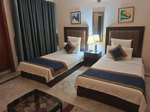 A bed or beds in a room at Hotel Gulberg Grand