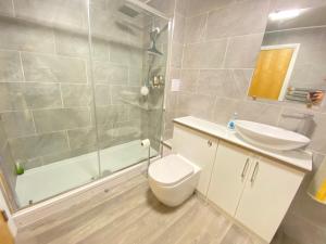 a bathroom with a toilet and a sink and a shower at Paisley Central Apartment in Paisley +13 photos