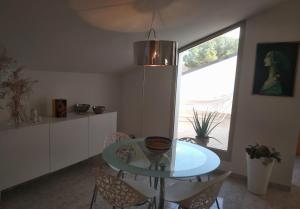 une salle à manger avec une table et des chaises en verre dans l'établissement Casa Vacanza Le Nid d'Assise, à Bastia Umbra