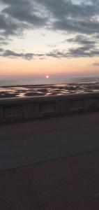 a sunset over the ocean with the sun in the sky at Sea-front Apartment home-from-home in Blackpool