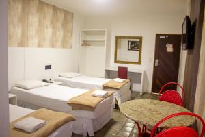 Llit o llits en una habitació de Caruaru Pallace Hotel