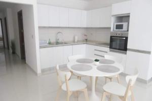 - une cuisine blanche avec une table et des chaises blanches dans l'établissement Sliema Ferries Apartment, à Sliema