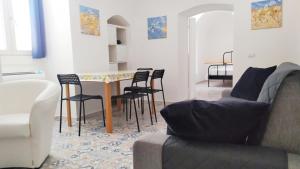 - un salon avec une table et des chaises dans l'établissement Dimora storica a Canosa di Puglia, à Canosa di Puglia