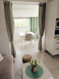 a living room with a table and a dining room at Appartement La Pinède in Gruissan