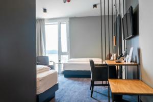 a hotel room with a bedroom with a desk and a bed at Hotel DEJANIL Hannover Burgdorf in Burgdorf +107 photos