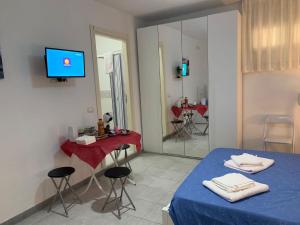 a room with a bed and a table and a mirror at Casa di Ale in Diamante