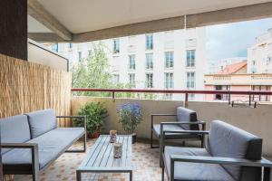 - un balcon avec des chaises et des tables dans un bâtiment dans l'établissement "CHAMPÊTRE" Confort, à Clermont-Ferrand