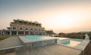 a building with a swimming pool in front of a building at Fateh Safari Resort by Fateh Collection in Kumbhalgarh