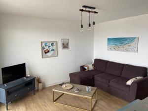 Una sala de estar con un sofá y una mesa de café. en Front de mer à Wimereux - Wifi-, en Wimereux 3 fotos más