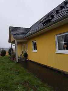 een geel huis met een dak bij große Ferienwohnung in Heiligenstedten