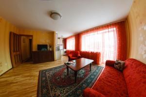 a living room with a red couch and a table at Tvirtovė in Vilnius