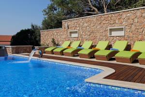 a pool with chaise lounge chairs and a swimming pool at Boutique Hotel Bol in Bol