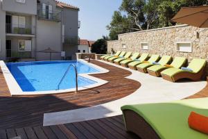 a swimming pool with lounge chairs next to a building at Boutique Hotel Bol in Bol