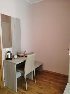 białe biurko z krzesłem w pokoju w obiekcie Adriatico Rooms w mieście Tarvisio