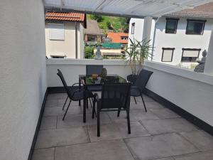 een patio met een tafel en stoelen op een balkon bij Ferienwohnung Jasmin in Schönau bei Heidelberg Fewo 1 mit Terrasse in Schönau