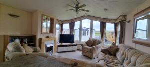 a living room with a couch and a tv at The Perrycroft at Forest Views Caravan Park in Plumbland
