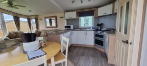 a small kitchen with a table in a tiny house at The Perrycroft at Forest Views Caravan Park in Plumbland